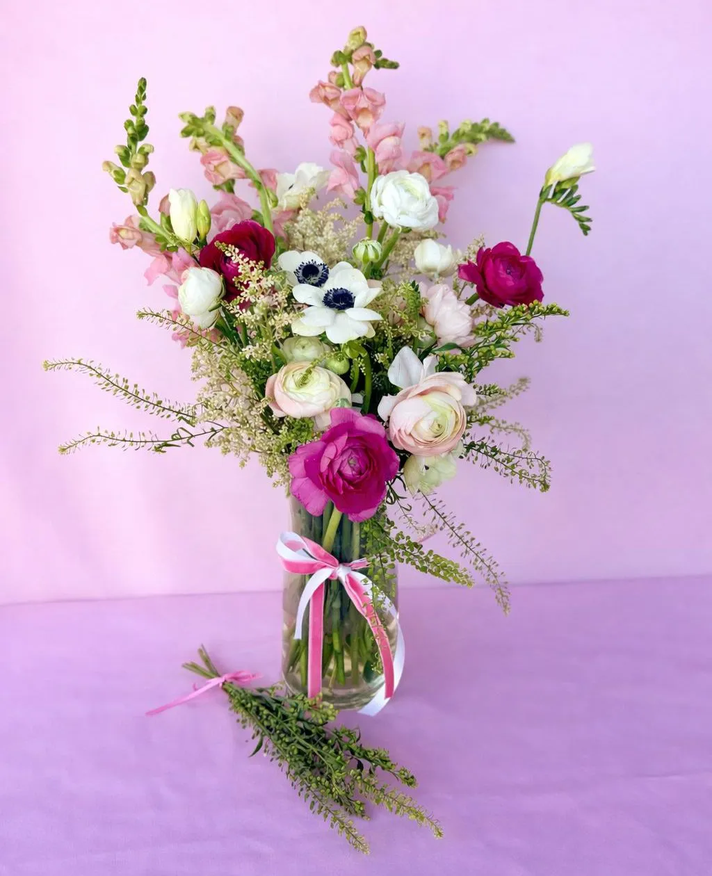 Garden-style bouquet of ranunculus and anemones in a keepsake vase